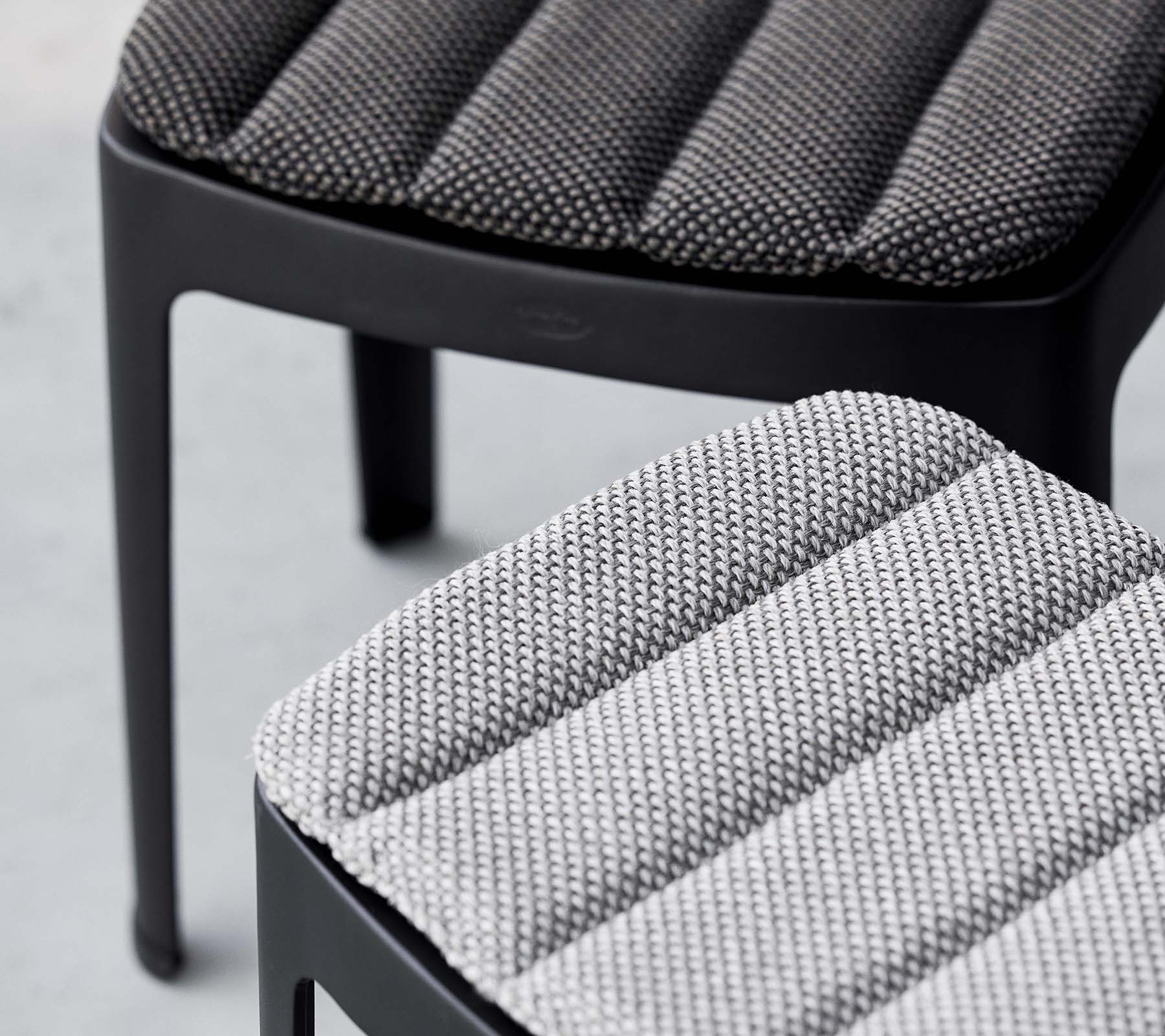 To stilfulde skamler med tekstureret polstring i kontrasterende nuancer af grå, der udviser et moderne design med elegante linjer.