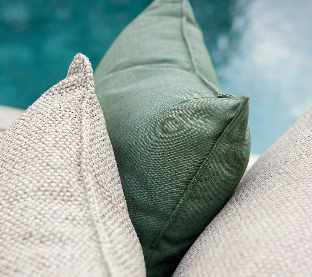 Grønne og grå puder arrangeret sammen.