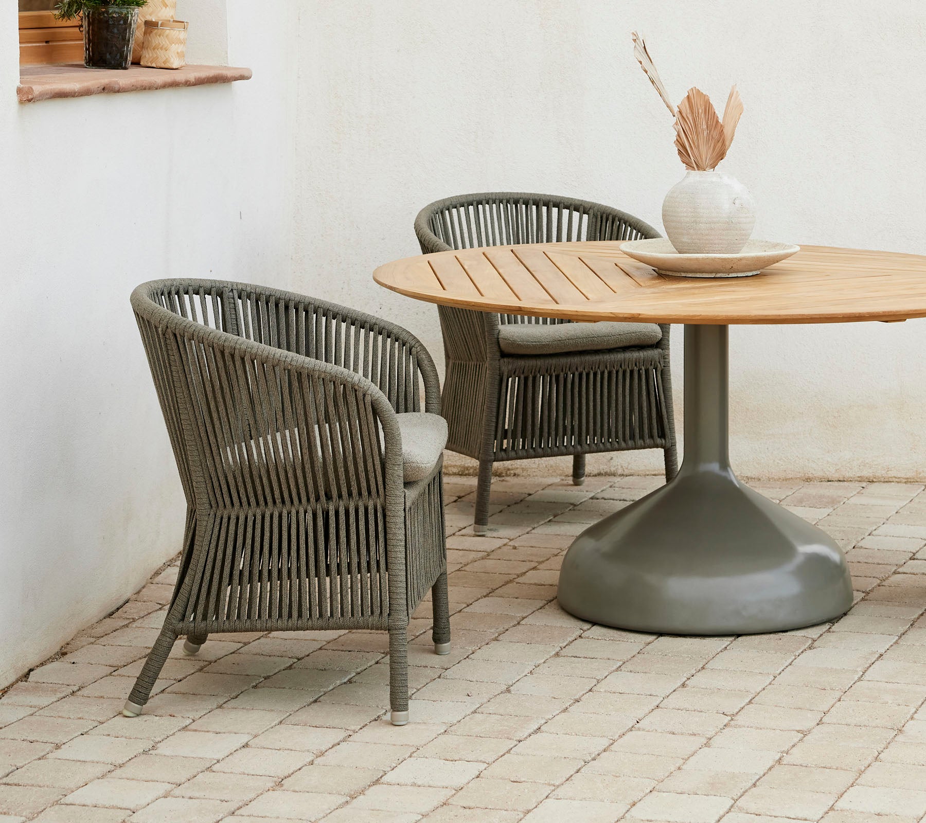 To stilfulde Derby stole parret med et rundt Glaze spisebord, prydet med en neutral farvepalet og en dekorativ vase.