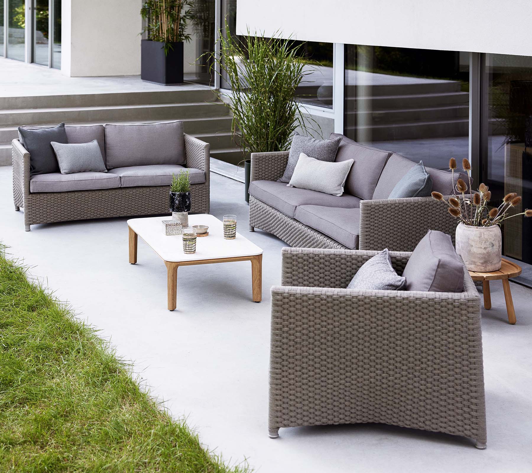 Stilfuld loungeområde med en diamant 2-personers sofa, diamant 3-personers sofa og en matchende loungestol, suppleret af et kaffebord.