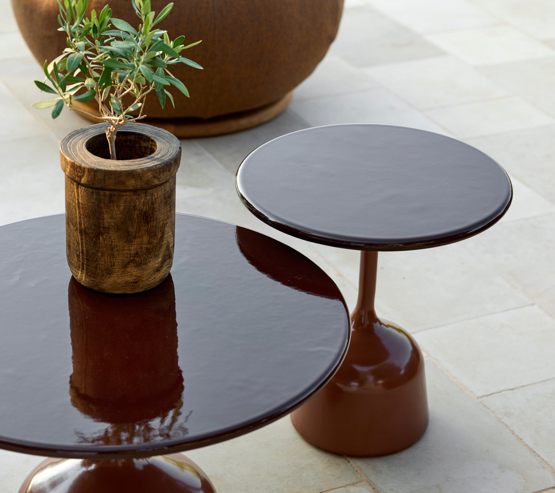 To moderne brune borde med en potteplante i en stilfuld loungeindretning.