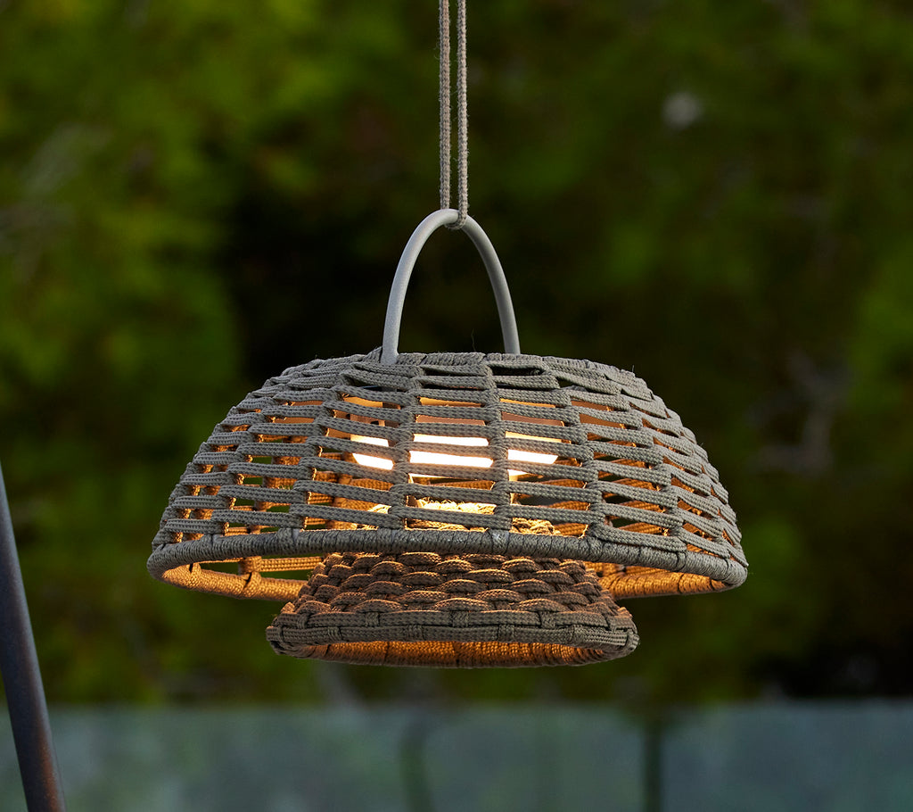 Taupe illusion lampe med et vævet design, der har en fremtrædende kuppelform og varmt lys, der udsender fra indeni, hvilket skaber en indbydende atmosfære.