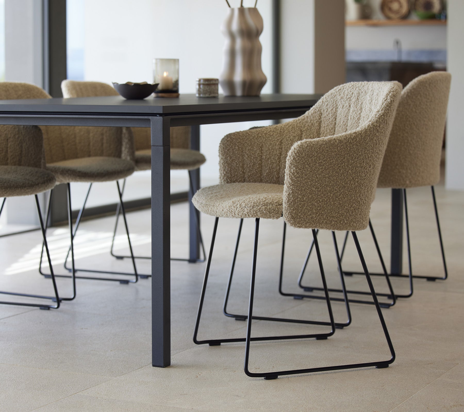 Et stilfuldt spisebord med teksturerede stole, der har et moderne design og minimalistiske elementer, sat op til en indbydende spiseoplevelse.