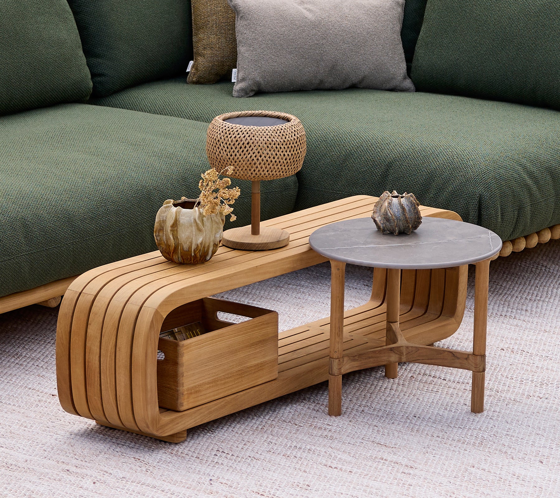 Moderne trækaffebord med et gråt sidebord, lampe og dekorativ vase i en loungestil.
