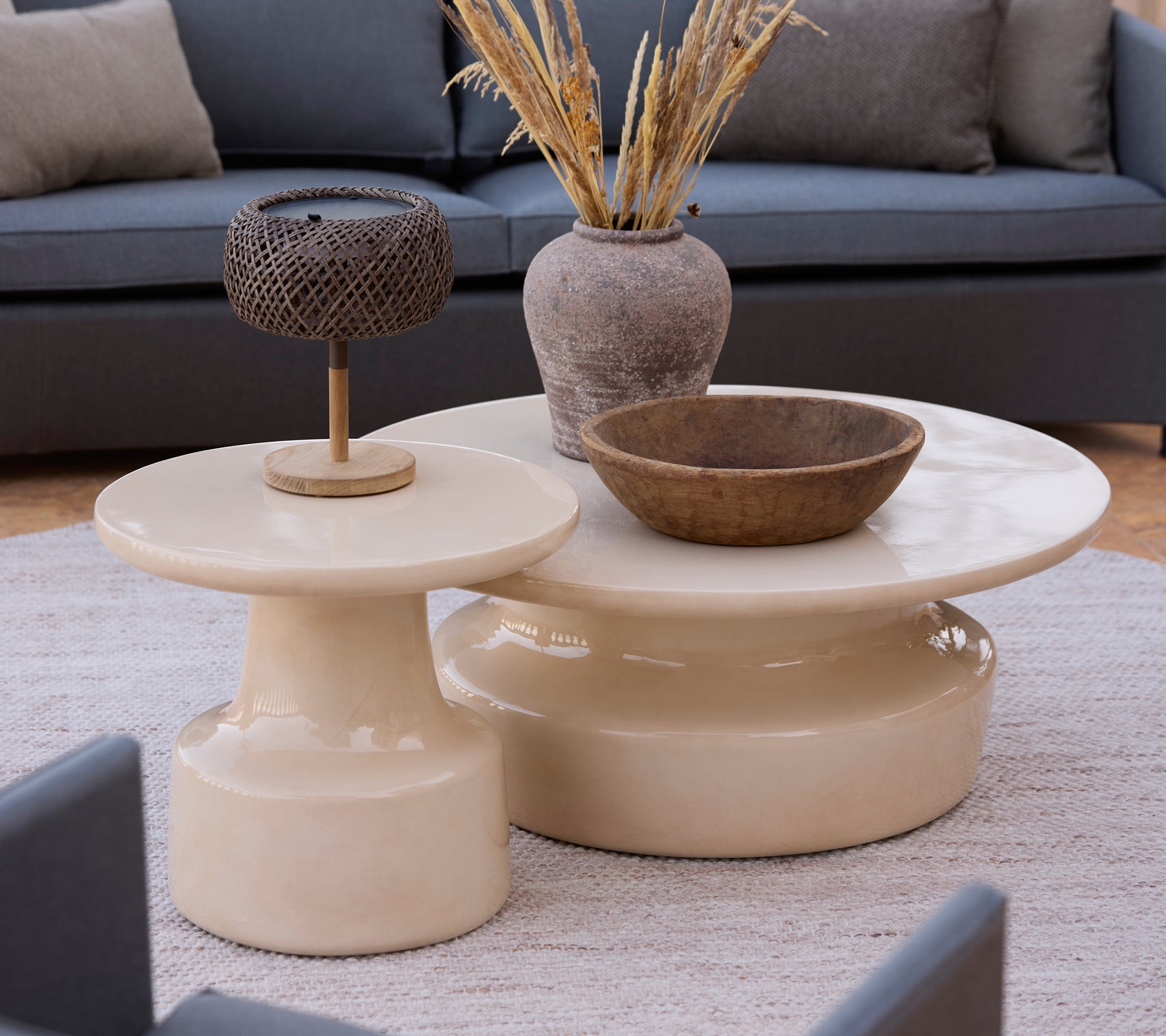 Moderne beige kaffeborde og sideborde med en brun skål og metallampe i en loungestil.