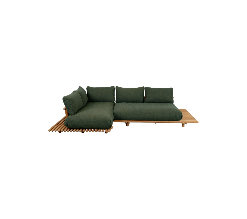 Moderne grøn sofa med en teakplatform i en afslappet loungeindstilling.