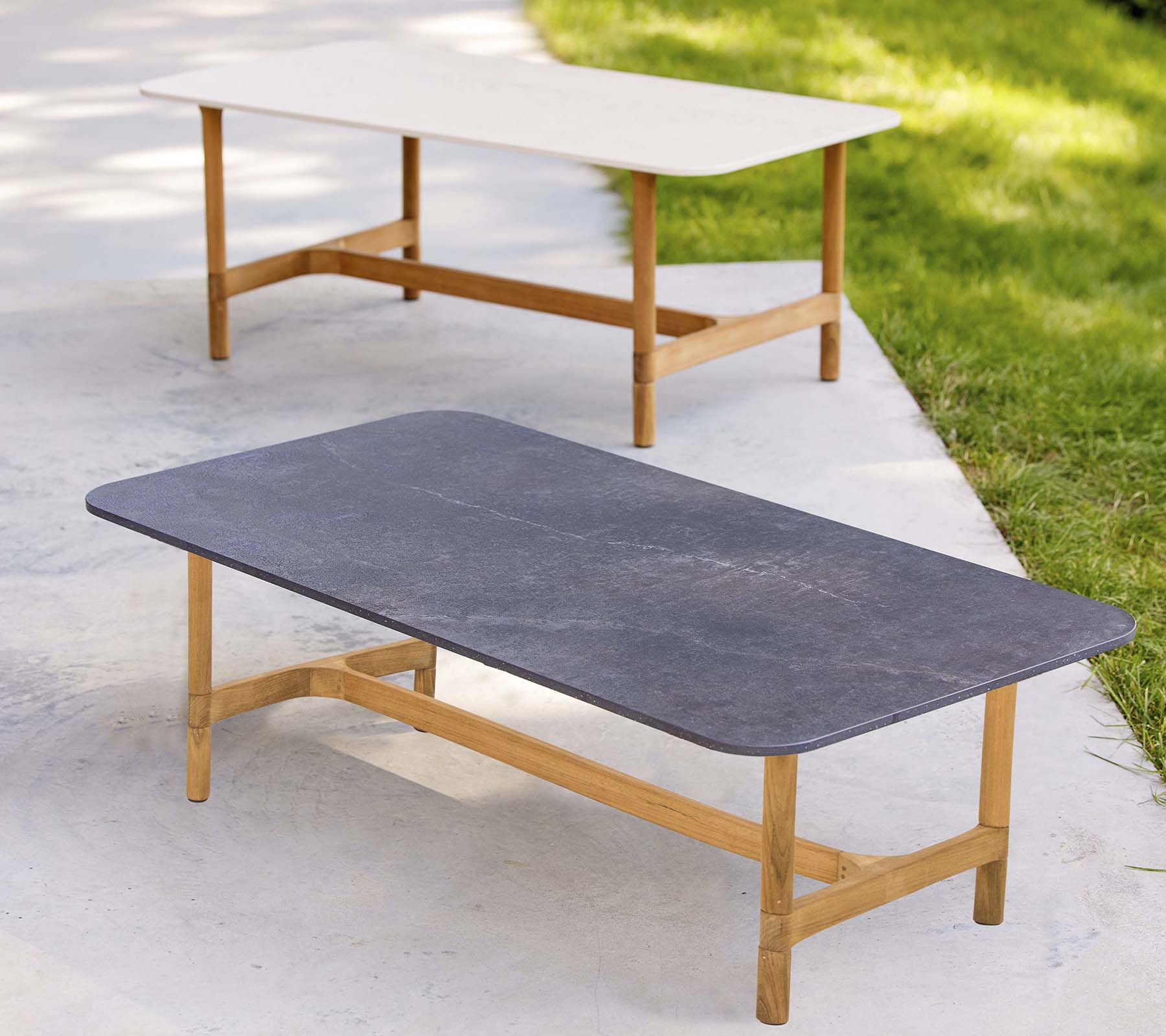 To stilfulde sofaborde med træreoler og kontrasterende bordpladefarver, der har et moderne, minimalistisk design.